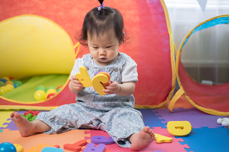 baby playing with colorful letter blocks