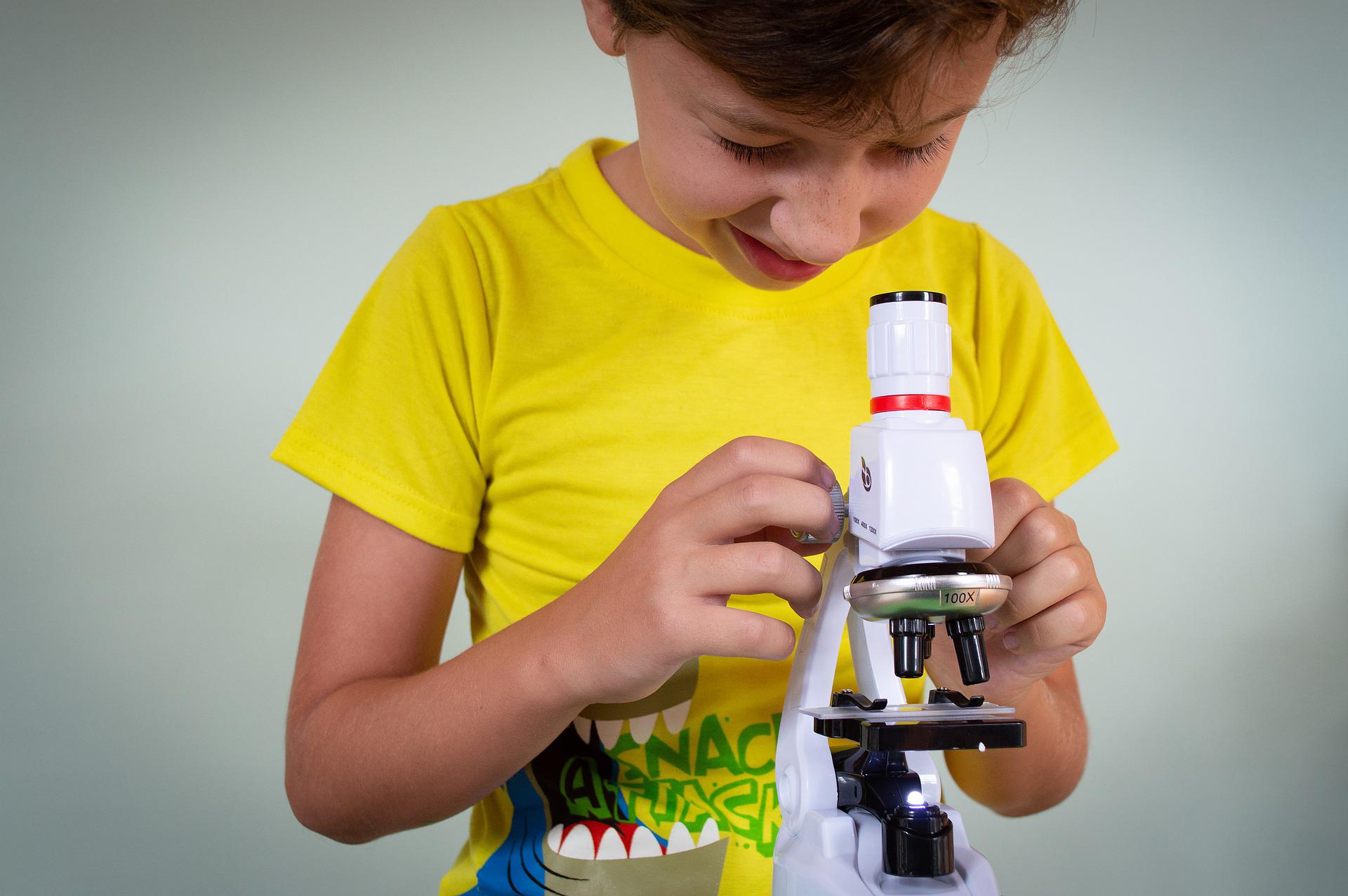 kid looking through microscope