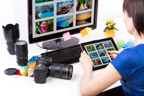 Picture of individual orgnizing photos on a computer.