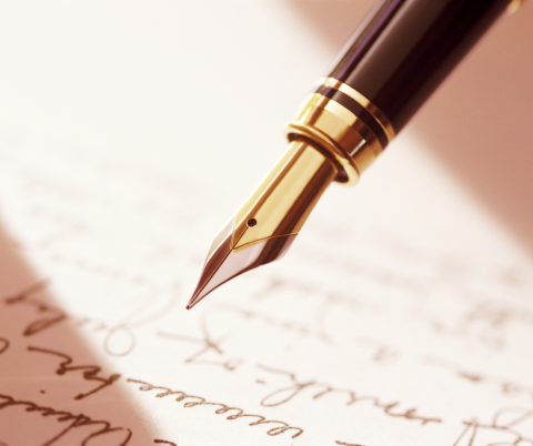 A pen hovering over a page of writing