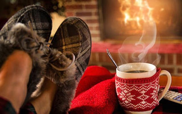 cozying up to fireplace with mug of tea